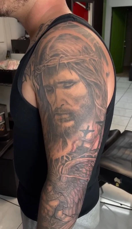 Benson Carlos black and gray realism Jesus tattoo upper arm Hawaii